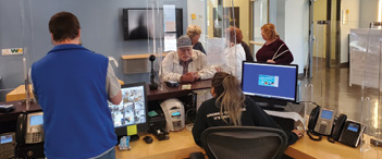 A group of people are gathered in a room, with some sitting at a desk and others standing. There are two TVs in the room, one on the left side and another on the right side. A computer is also present in the room, with a keyboard and mouse on the desk. A cell phone can be seen on the desk as well. The people in the room are engaged in conversation, creating a lively atmosphere.

AI generated content