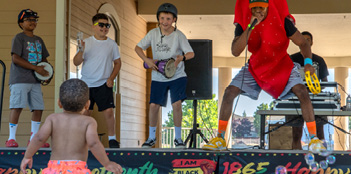 A man dressed as a hot dog sings into a microphone while a group of children watch.

AI generated content