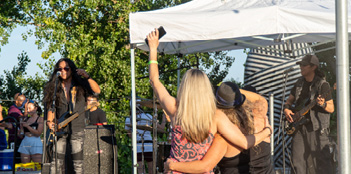 A woman is taking a picture of a band using her cell phone.

AI generated content