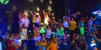 A group of people are dancing in a dark room, wearing neon clothing.

AI generated content