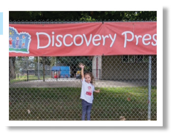 A young girl is standing on a ledge in front of a red banner.

AI generated content