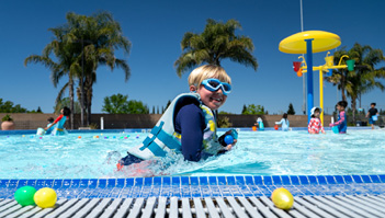A young boy wearing a life jacket and goggles is swimming in a pool.

AI generated content