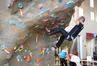 A man is climbing a rock wall, while others watch.

AI generated content