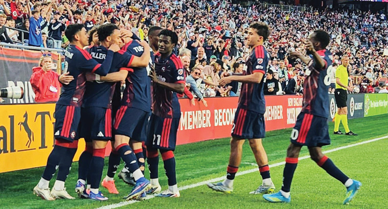 A group of soccer players celebrating on the field.

Description generated by AI