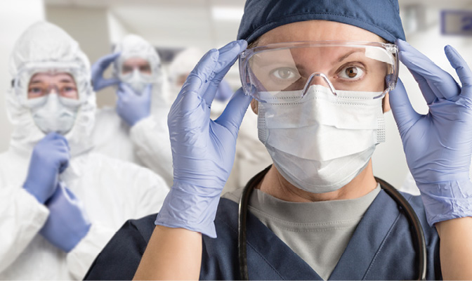 Team of Female and Male Doctors or Nurses Wearing Personal Protective Equipment In Hospital Hallway.