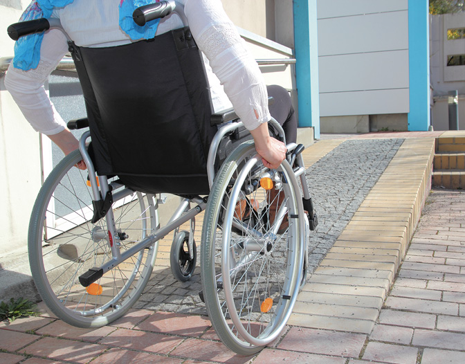 Woman in a wheelchair using a ramp.