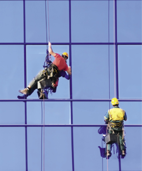Washers wash the windows of modern skyscraper.
