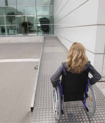 Woman in a wheelchair using a ramp.