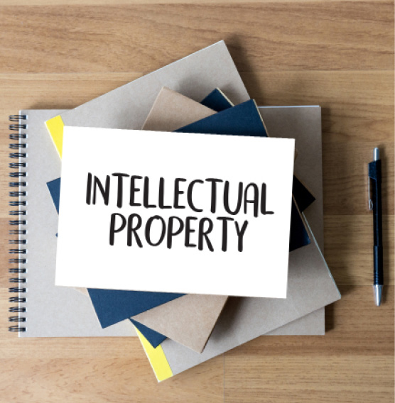 INTELLECTUAL PROPERTY Business team hands at work with financial reports and a laptop.