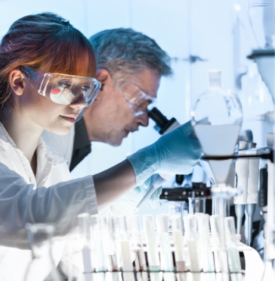 Health care researchers working in life science laboratory. Young female research scientist and senior male supervisor preparing and analyzing microscope slides in research lab.